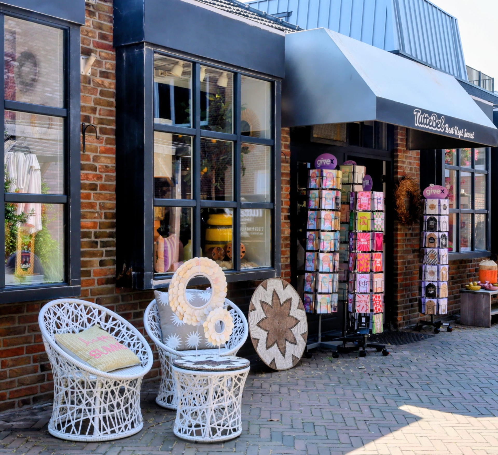 De winkelpui van Tuttebel met etalage, rieten stoelen en wenskaarten